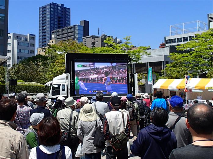High-performance mobile LED truck display trailer cruising through a high-traffic urban area.